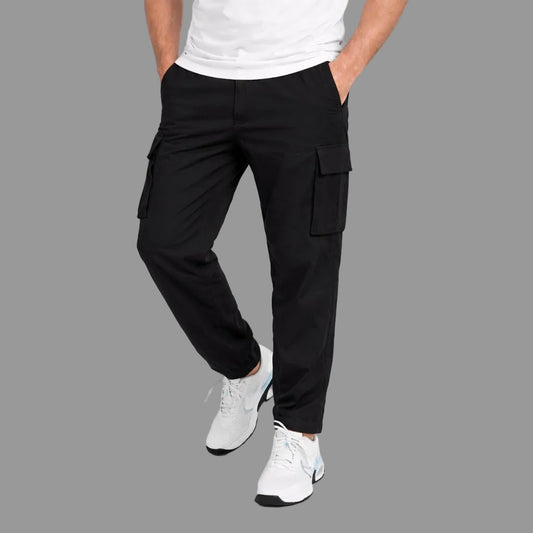 Person wearing black cargo pants and white sneakers on a white background